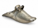 METAL PRATEADO, uma (1) sapata confeccionada em metal espessurado a prata, decorada por frisos geométricos em baixo relevo, apresentando falhas na prateação, medindo 11x30x12,5cm.