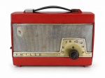 SOM, um (1) rádio portátil PHILCO TRANSISTONE II, material plástico na cor vermelha, com grade frontal metálica, mostrador analógico e alça superior para transporte. Apresenta inscrições Philco e Transistone II. Sinais de uso, riscos e desgastes compatíveis com a idade. Funcionamento não testado e sem garantia de funcionamento, medindo 18x24,5x10cm.