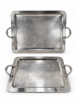 METAL PRATEADO, duas (2) peças bandejas retangulares confeccionados em metal espessurado da manufatura RIVA, fundo liso, alça cilíndrica em vazado decorado por gomos, apresentam sinais de oxidação, medindo 55x36cm e 44x31cm.