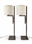 ABAJURES, par (2) de abajures para uma lâmpada, com estrutura geométrica em metal esmaltado na tonalidade escura, base retangular e cúpulas cilíndricas em tecido claro. Design de linhas retas, com fiação e interruptores aparentes. Sinais de uso, medindo 71cm de altura.