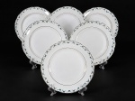 PORCELANA REAL, seis (6) pratos rasos confeccionados em porcelana na tonalidade branca, decorada por guirlanda floral em policromia e filetes em ouro, medindo 23,5cm. Falhas na douração e pintura, 2 com sinais de craquele. medindo 23,5cm.
