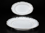PORCELANA REAL, duas (2) travessas ovais confeccionadas em porcelana na tonalidade branca, decorada por guirlanda floral em policromia e filetes em ouro, 1 bicado na borda, medindo 32,5x21cm e 28x18cm.