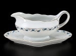 PORCELANA REAL, uma (1) molheira fixada ao presentoir confeccionada em porcelana na tonalidade branca, decorada por guirlanda floral em policromia e filetes em ouro, medindo 11x24x13,5cm.