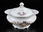 PORCELANA SCHMIDT, uma (1) sopeira confeccionada em porcelana nacional na tonalidade branca, decorada por flores e folhagens em policromia, elementos em relevo na pasta e borda filetada em prata, medindo 20x27,5x22,5cm. Leves falhas na prateação;