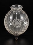 VIDRO, um (1) globo confeccionado em vidro translucido canelado, lapidado por flores e folhagens em baixo relevo, acabamento em metal dourado finalizado por pinha em bronze, medindo 25x20x10cm.