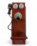 DIVERSOS, um (1) telefone antigo de parede, com caixa em madeira escura, campainhas duplas metálicas, bocal frontal e fone/receptor lateral com fio. Apresenta sinais de uso e desgastes compatíveis com a idade. Funcionamento não testado e sem garantia de funcionamento, medindo 57x25x18cm.