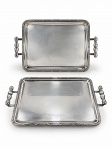 METAL PRATEADO, duas (2) bandejas retangulares confeccionadas em metal espessurado a prata da manufatura PRATA WOLFF, fundo liso, borda cinzelada por caneluras e fitas cruzadas com alças torneadas em vazados, apresentam sinais de uso, medindo 49x32,5cm.