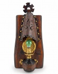 LUMINÁRIA, um (1) lampião de parede confeccionado em vidro na tonalidade âmbar com guarnição metálica com pintura dourada, acondicionada em suporte com estrutura em madeira e couro na tonalidade marrom com recortes e vazados, apresenta marcas do tempo e de uso com leves desgastes, medindo 61x26cm.