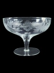 DEMI-CRISTAL, uma (1) fruteira confeccionada em demi-cristal translucido, lapidado por guirlanda floral e vegetalista em baixo relevo fosco, haste cilíndrica, apoiada sobre base circular, medindo 17,5x24cm.