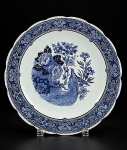 FAIANÇA / DELFTS - (1) Prato / Medalhão em faiança branca vitrificada  ,  com decoração monocromática em azul , apresentando ao centro composição com ave entre flores e folhagens. Borda ricamente ornamentada com motivos florais e arabescos, com borda recortada , medida : 30 cm
