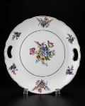PORCELANA SCHMIDT - (1) Prato para bolo em porcelana vitrificada branca , decoração floral , borda filetada à ouro com falhas na douração , pega vazada , medida : 26 cm
