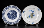 PORCELANA REAL / SCHMIDT - (2) Pratos fundos decorativos , sendo (A) - 1 em porcelana branca vitrificada da manufatura SCHMIDT , decoração floral e borda filetada à outro , medida : 23 cm e    (B) - 1 em porcelana branca vitrificada da manufatura REAL , decoração de cena campestre na tonalidade azul , medida : 23 cm