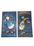 QUADROS, duas (2) talhas em madeira entalhada e policromada, com representações estilizadas de personagens de desenho animado, sendo um deles inspirado no Pato Donald. Trabalhos assinados Edilson no canto inferior. 1 apresenta sinais de cupim, medindo 44x25,5cm e 44x24,5cm (com sinais de cupim).