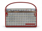 SOM, um (1) rádio portátil GRUNDIG, de fabricação alemã, na cor vermelha, com sintonizador analógico em ondas médias (MW), grade frontal metálica e alça superior para transporte. Apresenta inscrições Grundig e Made in Germany. Sinais de uso e desgastes compatíveis com a idade. Funcionamento não testado. Peça no estado, medindo 11x18cm.