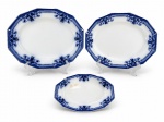 Johnson Bros "Royston", três (3) travessas ovais dodecagonais confeccionadas em faiança inglesa na tonalidade branca, decorada por elementos florais e vegetalistas na tonalidade azul borrão, maior medindo 29,5x23cm, média 26,5x21cm (fio de cabelo na borda) e menor 20,5x12,5cm (bicada na borda e com marcas do tempo). Peças possuem sinais de craquele.