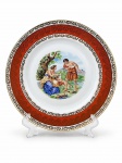 PORCELANA DE BAVARIA, um (1) prato fundo decorativo confeccionado em porcelana alemã na tonalidade branca, decorado por cena idílica em policromia, espessa faixa na tonalidade vermelha com guirlanda floral em vasta douração, leves falhas na douração, medindo 23cm de diâmetro.