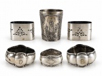 METAL PRATEADO, lote com seis (6) peças de modelos, tamanhos e decorações distintas, sendo: A) 5 porta guardanapos em metal espessurado a prata, maior medindo 4x5x2,5cm e menor 3x4,5x3cm e B) 1 copo em estanho com leves mossas na borda, medindo 7x5,5cm.