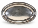 METAL PRATEADO, uma (1) grande travessa oval confeccionada em metal espessurado a prata da manufatura WOLFF, borda cinzelada em caneluras e fitas cruzadas, apresentando falhas no banho, medindo 45,5cm.