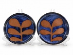 CERÂMICAS, dois (2) pratos decorativos confeccionados em cerâmica vitrificada assinada CIDA, decorada por folhagens sobre fundo azul, medindo 16cm e 15cm.