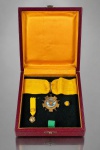 MILITARIA, conjunto de condecorações da ORDEM MEXICANA DA ÁGUIA ASTECA (ORDEN DEL ÁGUILA AZTECA), instituída pelo Decreto Presidencial de 29 de dezembro de 1933, durante o governo de Abelardo L. Rodríguez, considerada a mais alta distinção concedida pelo Governo do México a cidadãos estrangeiros, civis ou militares, em reconhecimento aos relevantes serviços prestados à nação mexicana ou à humanidade, bem como ao fortalecimento das relações diplomáticas e de amizade entre as nações. Conjunto composto por três (3) peças, confeccionadas em PRATA DE LEI, com acabamento dourado e esmaltação policromada, sendo: condecoração principal em formato estrelado, com ornamentações de inspiração asteca em relevo, apresentando medalhão central esmaltado em azul-turquesa com representação da Águia Asteca de Cuauhtémoc, suspensa por fita de tecido amarelo-ouro; medalha em miniatura com fita correspondente e distintivo de lapela. Acondicionadas em estojo revestido em tom vinho, com interior em cetim dourado e base aveludada preta, maior medalha medindo 8cm com a argola e 4,5cm de diâmetro, menor medalha 1,5cm.