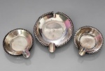 PRATA DE LEI, três (3) cinzeiros circulares confeccionados em PRATA DE LEI, sendo 2 com borda perolada, medindo 5,5cm e 1 com frisos torcidos com quebra na borda, medindo 7,5cm. Peso total 36g.
