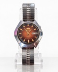 RELÓGIO, um (1) relógio de pulso masculino ORIENT 3 ESTRELAS (THREE STARS), AUTOMATIC, 21 JEWELS, de fabricação japonesa, com mecanismo mecânico automático de 21 rubis, apresentando caixa em metal prateado, de formato geométrico, mostrador circular em tom marrom degradê, com marcadores de horas e ponteiros dourados, pontos luminescentes e calendário duplo com indicação do dia da semana e data na posição das 3 horas. Pulseira metálica extensível em aço, de elos articulados. Tampa traseira em aço inoxidável, com brasão da marca ORIENT em relevo, inscrições ALL STAINLESS STEEL e WATER RESISTANT, além de numeração de referência gravada. Peça vintage, apresentando riscos, e marcas de uso, guarnição do calendário solta, perto dos ponteiros, não testado e sem garantia de funcionamento, caixa medindo 3,5cm.