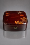ARTE ORIENTAL, uma (1) caixa porta joias de inspiração japonesa, confeccionada em madeira laqueada, de formato quadrangular com cantos arredondados, apresentando acabamento em laca vermelho-escura, com delicadas ornamentações policromadas e douradas, representando libélula, folhagens e motivos vegetais, ao gosto da tradicional arte japonesa. Tampa superior articulada, com inscrição em caracteres orientais acompanhada de selo vermelho, e fecho frontal com espelho de fechadura em metal trabalhado. Apresenta na base etiqueta dourada com inscrição L.T. PIVER  PARIS  FRANCE, tradicional casa francesa de perfumaria fundada no século XVIII. Peça de interesse artístico, histórico e colecionável, apresentando marcas acentuadas do tempo, riscos, desgastes, manchas e leves perdas no acabamento laqueado, medindo 7,5x21x18cm. Não possui chave.