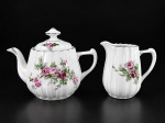 PORCELANA REAL (1943 a 1948), duas (2) peças para chá confeccionadas em porcelana na tonalidade branca, moldada em caneluras, com pintura de flores e folhagens em policromia com borda filetada em verde, sendo: A) 1 bule para chá, medindo 15x21x9,5cm, B) 1 leiteira, medindo 13x12x6cm, sinais de craquele.
