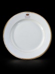 Breul à Paris, um (1) prato decorativo de porcelana europeia na tonalidade branca, borda dourada adornada por brasão contendo coroa de conde, apresenta falhas na douração e no brasão, medindo 23cm de diâmetro.