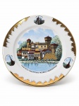 PORCELANA SCHIRNDING BAVARIA, um (1) prato decorativo confeccionado em porcelana alemã na tonalidade branca, comemorativo da cidade de Turim, Itália, apresentando ao centro representação policromada do conjunto arquitetônico medieval, com inscrição "Torino  Valentino  Borgo Medioevale", realces raiados em ouro, medindo 24,5cm.