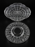 VIDROS, lote com duas (2) peças confeccionadas em vidro transluido, sendo: A) 1 travessa oval para frios com moldagem geométrica e ondulações na borda, gravado PRADO, medindo 40,5x27cm e B) 1 presentoir para centro de mesa em vidro americano com guirlanda floral em baixo relevo, medindo 29cm.