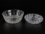 CRISTAL e VIDRO, lote com duas (2) peças, sendo: A) 1 saladiera confeccionada em cristal translucido com lapidação geométrica, caneluras e borda em ondulações, medindo 9x22,5cm e B) 1 cinzeiro em vidro prensado de tom azulado com moldagem geométrica, medindo 5x20cm.