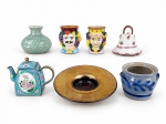 DIVERSOS, sete (7) peças de modelos, tamanhos, decorações e materiais distintos, sendo: A) 1 castiçal em vidro com folha de ouro, medindo 13,5cm, B) 2 pequenos copinhos em faiança, 1 bicado na base, medindo 6x4,5cm, C) 1 pequeno pote sem tampa em cerâmica, medindo 6,5x7cm, D) 1 sino em faiança, mediondo 7x6,5cm, E) 1 pequeno bule em metal esmaltado, medindo 8,5x19,5cm e F) 1 pequeno vaso bojudo em celadon, medindo 6cm de altura.