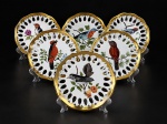 PORCELANA, um (1) conjunto composto por 6 pratos decorativos em porcelana branca vitrificada, com bordas vazadas, realçadas em dourado, apresentando pinturas à mão de aves sobre galhos com frutos e folhagens, em decoração policromada , medida : 19 cm