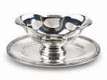 METAL PRATEADO, uma (1) molheira fixada ao presentoir confeccionada em metal espessurado a prata da manufatura FRACALANZA, borda cinzelada em caneluras e fitas cruzadas e alças laterais vazadas, banho novo, medindo 9,5x26x17cm.