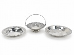 METAL PRATEADO, três (3) uveiras confeccionadas em metal espessurado a prata de modelos distintos, cinzelados por elementos vegetalistas em vazados e bordas em ondulações, medindo 12cm, 14cm e 16cm.