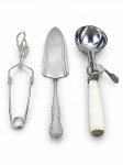 METAL PRATEADO, lote com três (3) peças, sendo: A) 1 tesoura para salada em metal espessurado a prata, B) 1 pá para bolo em aço inox e C) 1 colher para sorvete em aço inox e cabo em material sintético na tonalidade branca. Peças com sinais de uso.