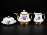 PORCELANA MAUÁ, conjunto para chá composto por três (3) peças: um (1) bule , med : 14 cm , uma (1) leiteira , med : 10 cm  e uma (1) manteigueira , medida: 8 x 15 cm , com tampa e prato presentoir. Confeccionadas em porcelana branca vitrificada, com corpos facetados, delicada decoração floral policromada em tons de rosa, lilás, azul e verde, enriquecida por largas faixas douradas, filetes e alças com acabamento em douração. Apresentam falhas na douração