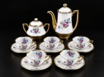 PORCELANA MAUÁ - Conjunto para café composto por sete (7) peças, sendo um (1) bule , med : 19 cm , um (1) açucareiro , med : 11 cm  e cinco (5) xícaras acompanhadas de seus respectivos pires , med : 4 cm . Confeccionadas em porcelana branca vitrificada, com corpos facetados, delicada decoração floral policromada em tons de rosa, lilás, azul e verde, enriquecida por largas faixas douradas . Possui falhas na douração .