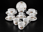 PORCELANA REAL, nove (9) xícaras com seus respectivos pires confeccionadas em porcelana na tonalidade branca, pintura floral em policromia com filetes em ouro, sendo: A) 3 xícaras para chá, medindo 5,5x11x8,5cm e B) 6 xícaras para café, medindo 5x7x5cm, 1 bicada na borda.