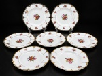 PORCELANA MAUÁ, sete (7) pratos fundos confeccionados em porcelana na tonalidade branca, decorada por flores e folhagens em policromia, bordas onduladas filetadas com caneluras em ouro, leves falhas na douração, medindo 23,5cm.