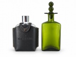 DIVERSOS - Conjunto de duas (2) peças, sendo: Um (1) cantil de bolso em vidro , com tampa rosqueável e revestimento em couro preto com costuras aparentes e inscrição "TOQUE ESPECIAL"; medida :  16 cm e uma (1) licoreira em vidro verde translúcido, de corpo achatado, formato retangular com cantos arredondados e tampa com pegador formado por duas esferas sobrepostas. Medida : 23 cm