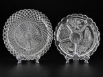 VIDROS, duas (2) peças confeccionadas em vidro translucido, sendo: A) 1 prato para bolo com moldagem geométrica e borda dentada, medindo 35,5cm e B) 1 petisqueira com 4 divisórias e 1 recipiente para molho com moldagem de verduras, folhagens, frutos e peixe em baixo relevo, medindo 31,5cm de diâmetro.