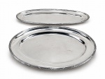 METAL PRATEADO, duas (2) travessas, sendo: A) 1 para peixe, medindo 61x24cm e B) 1 oval, medindo 48,5x37cm, confeccionadas em metal espessurado a prata da manufatura FRACALANZA, borda cinzelada em caneluras e fitas torcidas, alças laterais vazadas, apresenta leves sinais de uso.