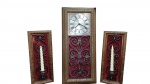 Conjunto decorativo de três peças para parede, composto por 1 relógio central com moldura de madeira entalhada floral e fundo em ferro forjado sobre veludo vermelho, acompanhado por 2  apliques laterais em formato de castiçais no mesmo padrão. medindo : Relógio: 3 x 76 x 34 cm e  Castiçais: 3  x 52  x 22 cm cada. Detalhes Técnicos: Relógio com visor analógico de numeração romana, mecanismo operado a pilha , parte traseira em chapa de fibra de madeira, bocal em metal pintado e acabamento rústico detalhado . Peça em bom estado geral de conservação (mecanismo não funcionando), ideal para decoração de interiores de estilo clássico ou rústico.