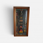 Quadro Vitrine Náutico - Equipamentos de Mergulho em caixa expositora em madeira e vidro contendo miniaturas detalhadas e identificadas de equipamentos antigos de mergulho (escafandro, máscara, barbatanas, garrafa de ar, entre outros). Peça decorativa.  Medidas: 50 x 26 cm