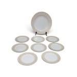Jogo para Bolo em Porcelana Europeia "RM Fine Porcelain" Composto por 1 prato/travessa principal (32 cm de diâmetro) e 8 pratos individuais (20 cm de diâmetro). Porcelana fina branca com elegante aba decorada em relevo floral e arabescos. Marcação na base . Em excelente estado.