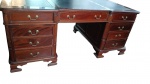 IMPORTANTE MESA DE ESCRITÓRIO EXECUTIVA DUPLA  FACE   Estilo Inglês Clássico, meados do Séc. XX (c. anos 1950/1970).   estruturada em madeira nobre. Tampo tripartido revestido em couro com acabamento pirogravado   com 12 gavetas distribuídas frente e 2 portas de armário nos pedestais laterais. Colunas angulares decoradas com caneluras verticais e puxadores/espelhos de fechadura em metal trabalhado.  Medidas: 1,80 m (comprimento) x 1,04 m (largura) x 0,78 m (altura).Apresenta marcas de uso e do tempo compatíveis com a época e o material. Sem chave. ( Retirada com agendamento na Barra da Tijuca)