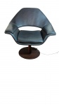 CADEIRA  GIRATÓRIA MODERNISTA.Revestida em couro marrom com  braços envolventes. Base disco e coluna central em madeira. Marcas do tempo e pequenos arranhões na base. Medidas: 90 x 85 cm. Assento: 56 x 48 cm. ( Reirada com agendamento na Barra da Tijuca)