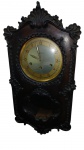 RELÓGIO DE PAREDE CARRILHÂO "A REGULADORA"   (Portugal). Caixa em madeira nobre ricamente entalhada com relevos decorativos. Mostrador prateado com numeração arábica, aro dourado e três furos de corda. Visor inferior recortado para visualização do pêndulo. Acompanha chave para dar corda.  Medidas: 72 x 37 cm. Necessita revisão .